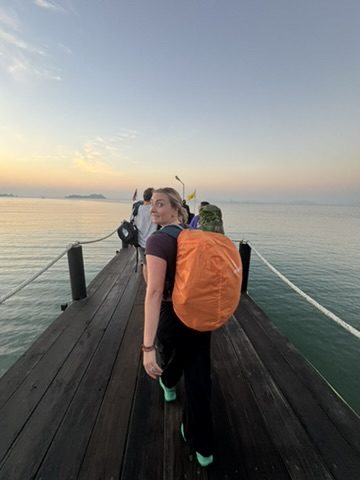 Meg at the pier with orange backpack