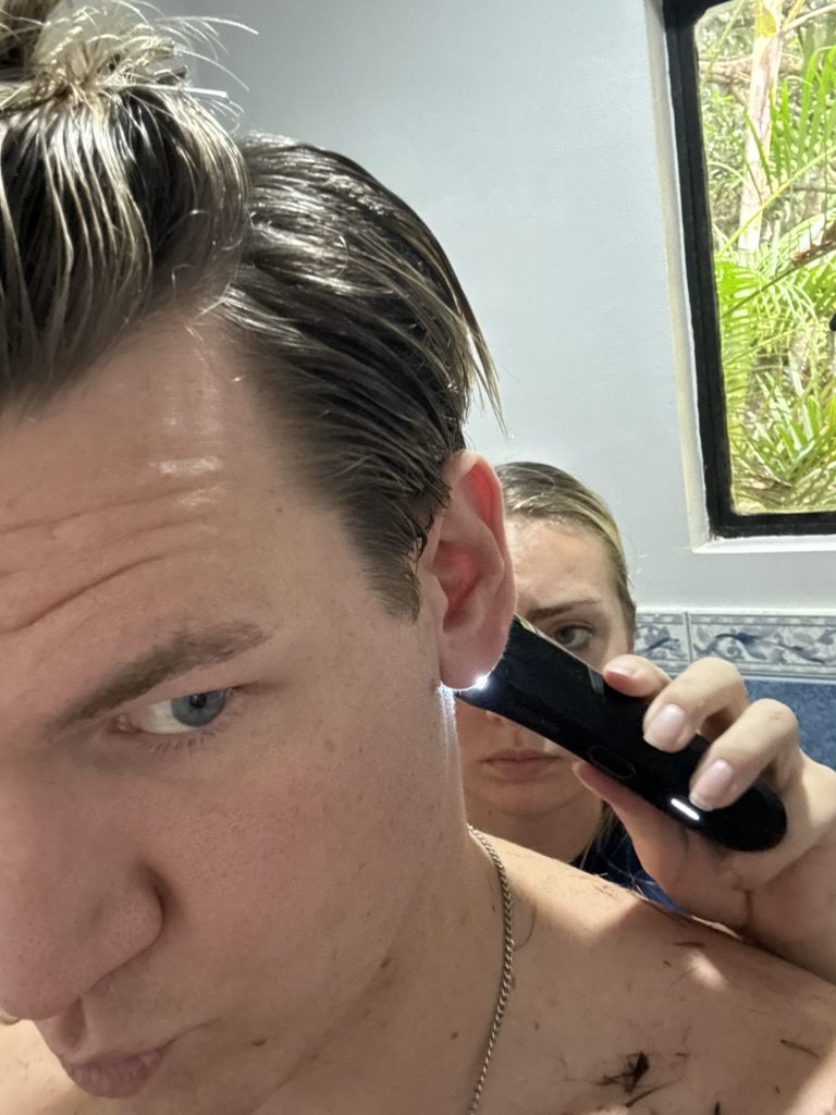 Meg giving Ryker a haircut with clippers in the Coron Airbnb bathroom