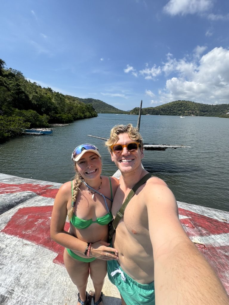 Meg and Ryker smiling at the waterfront near the crashed plane geocache location