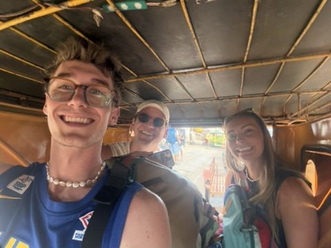 Miles, Ryker, and Meg smiling inside a tuk-tuk in the Philippines