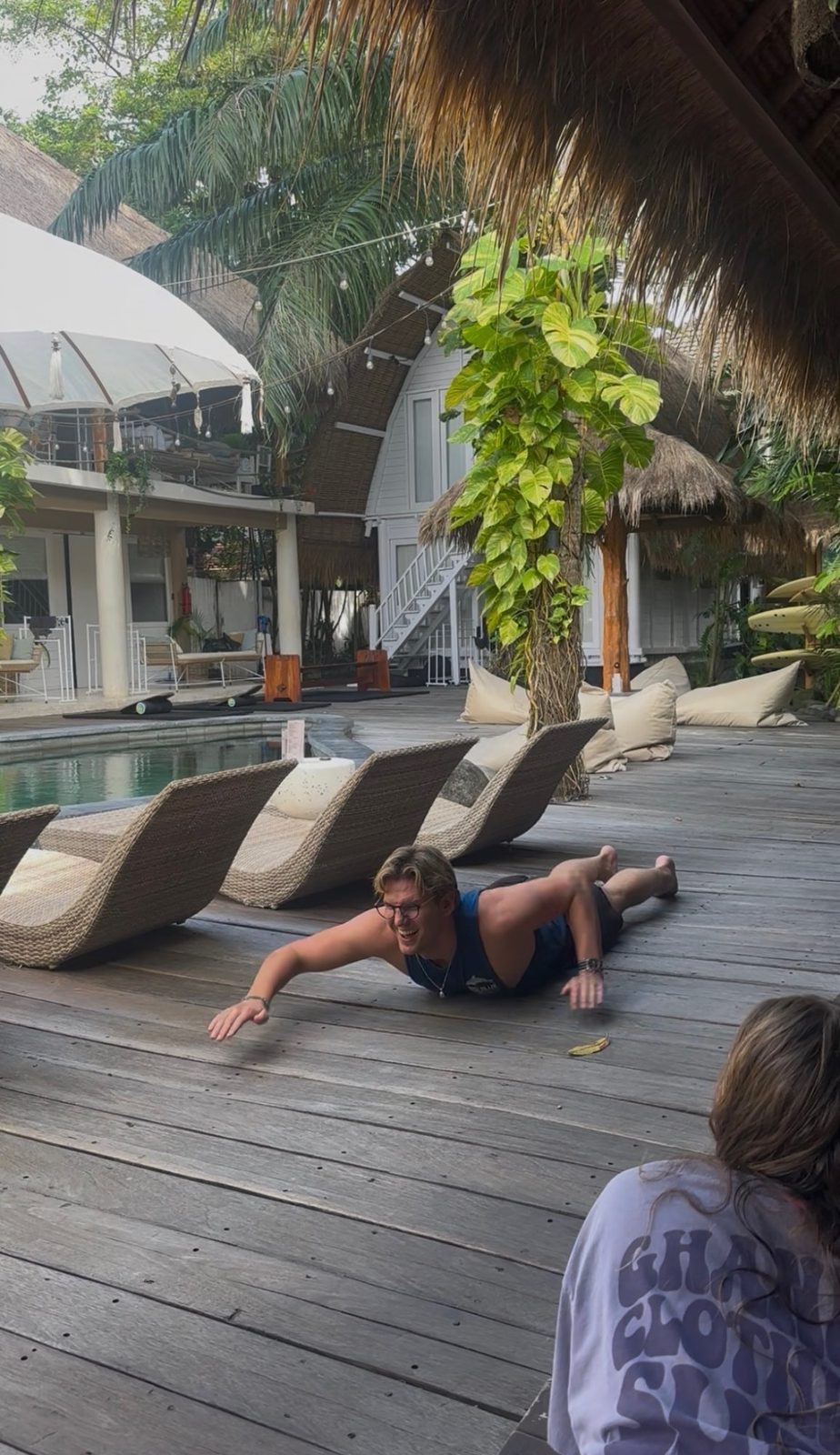 Fraser practicing his surf pop-up move flat on the wooden deck of KIMA camp, grinning wildly