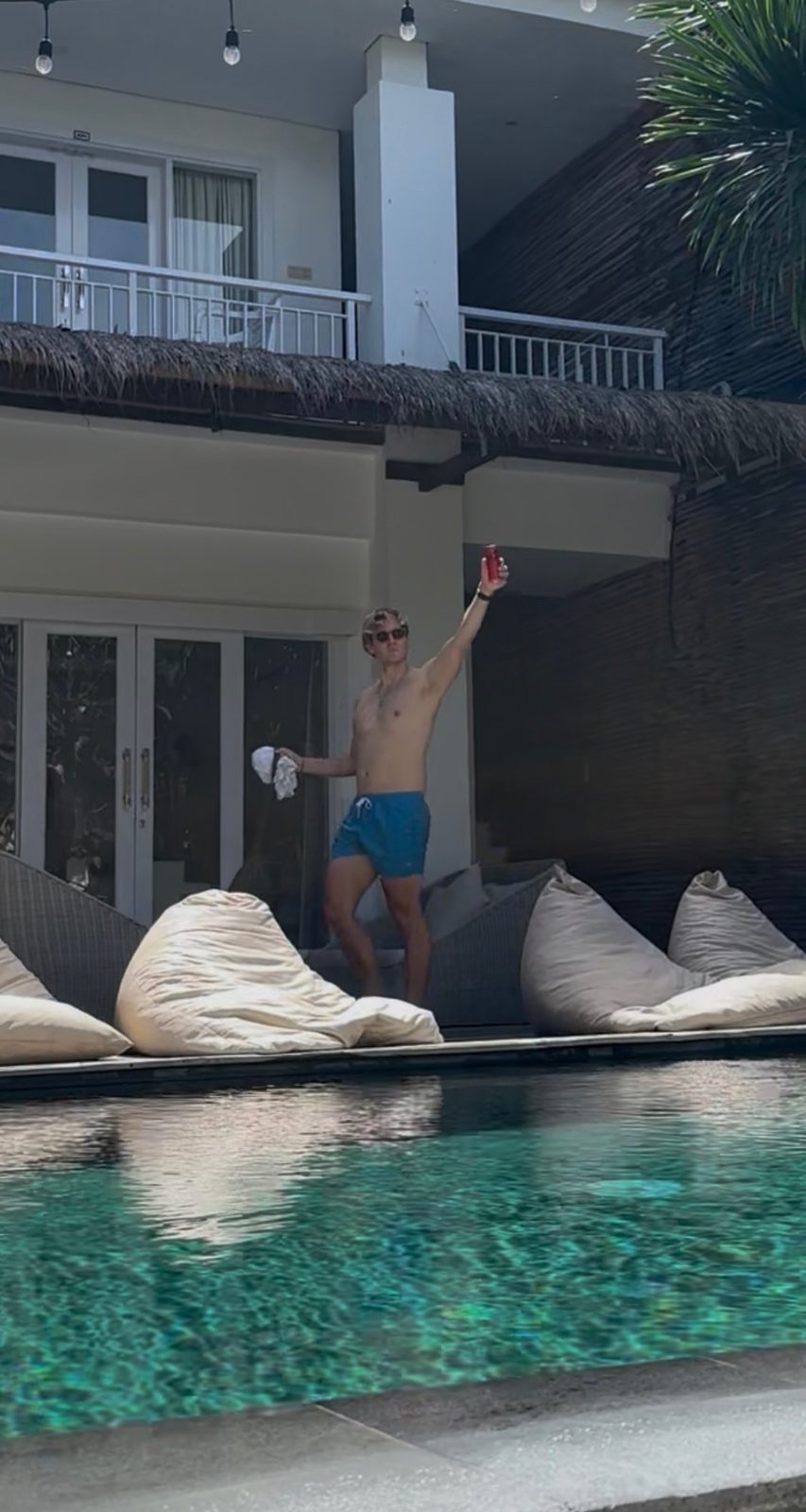 Ryker celebrating poolside at KIMA with a raised beer can and big grin