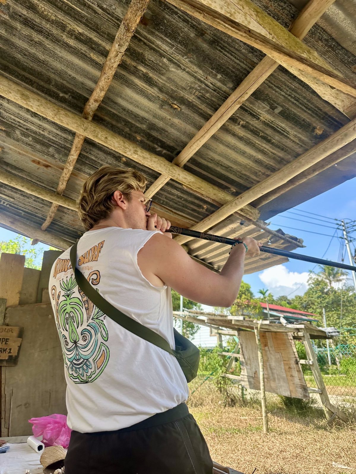 Ryker aiming a traditional Borneo blowpipe, concentrating hard