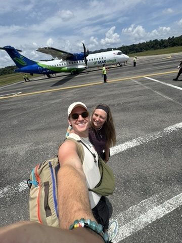 Ryker and Meg selfie on the tarmac in front of the MASWings propeller plane