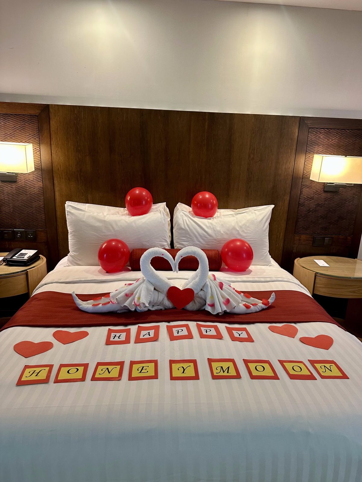 Marriott Mulu honeymoon suite — towel swans, red balloons, rose petals and Happy Honeymoon letters on the bed