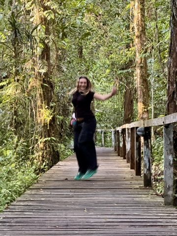 Meg laughing and skipping down the jungle boardwalk in Mulu National Park
