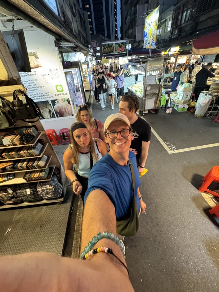 Group selfie in the night market alley