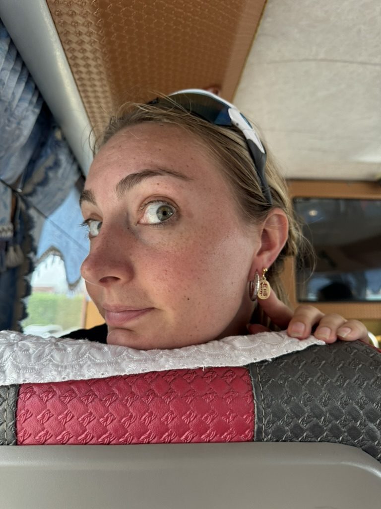 Meg peering over the car seat on the drive