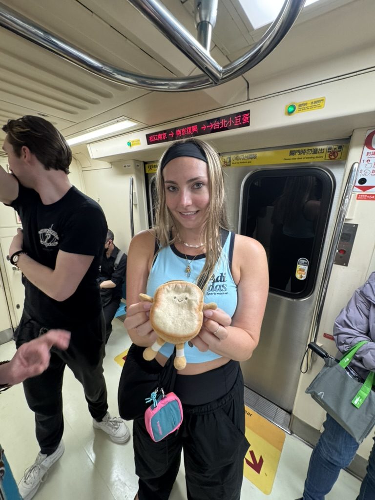 Meg on the MRT holding a dumpling plushie