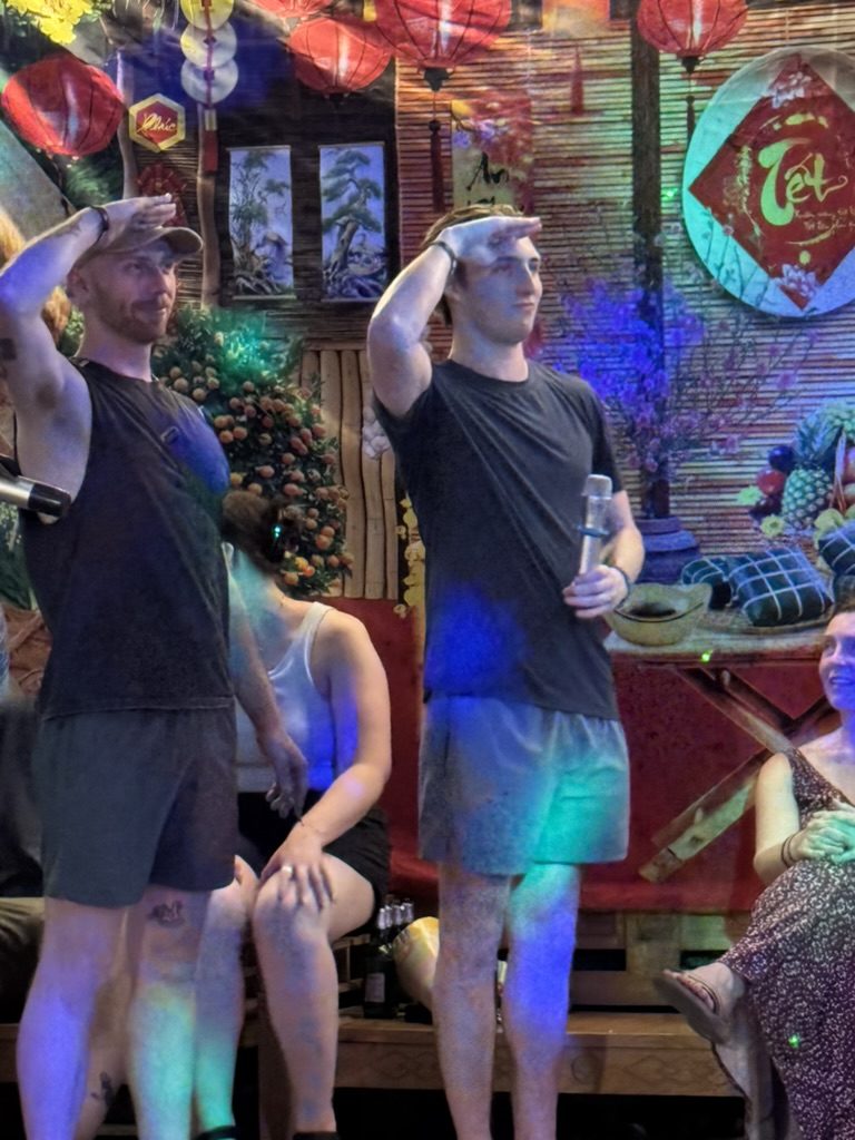 Ryker and August doing karaoke salutes at the Ha Giang bar