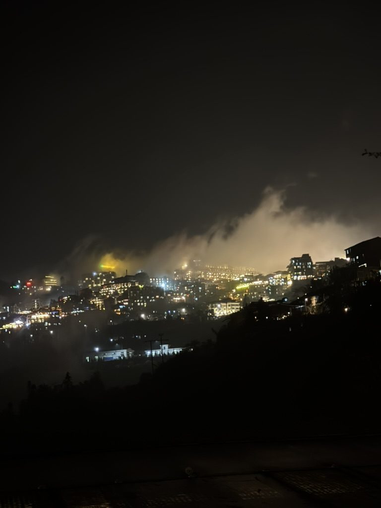 Sapa town lights glowing through the fog at night