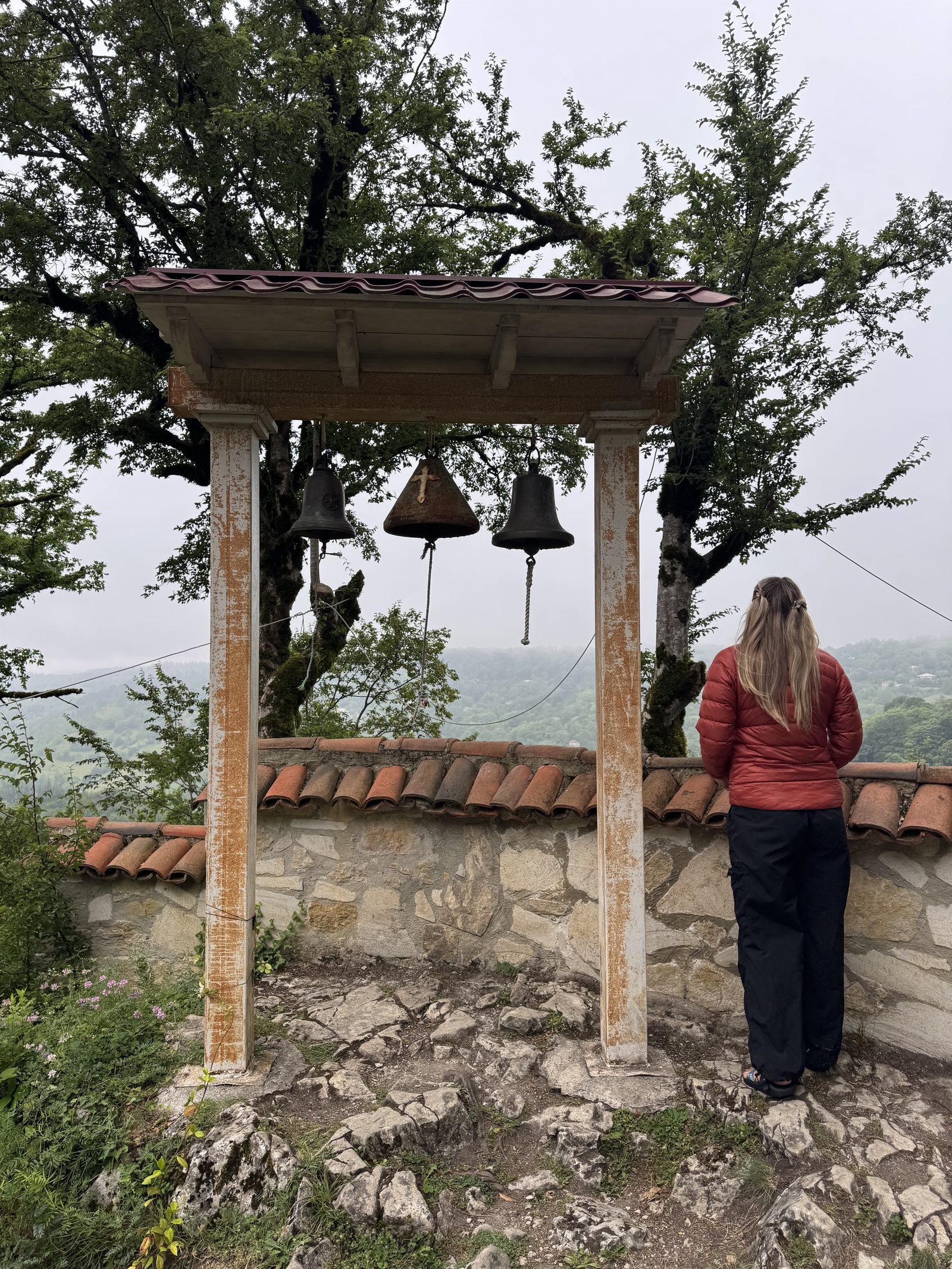 A stone bell arch at a countryside viewpoint