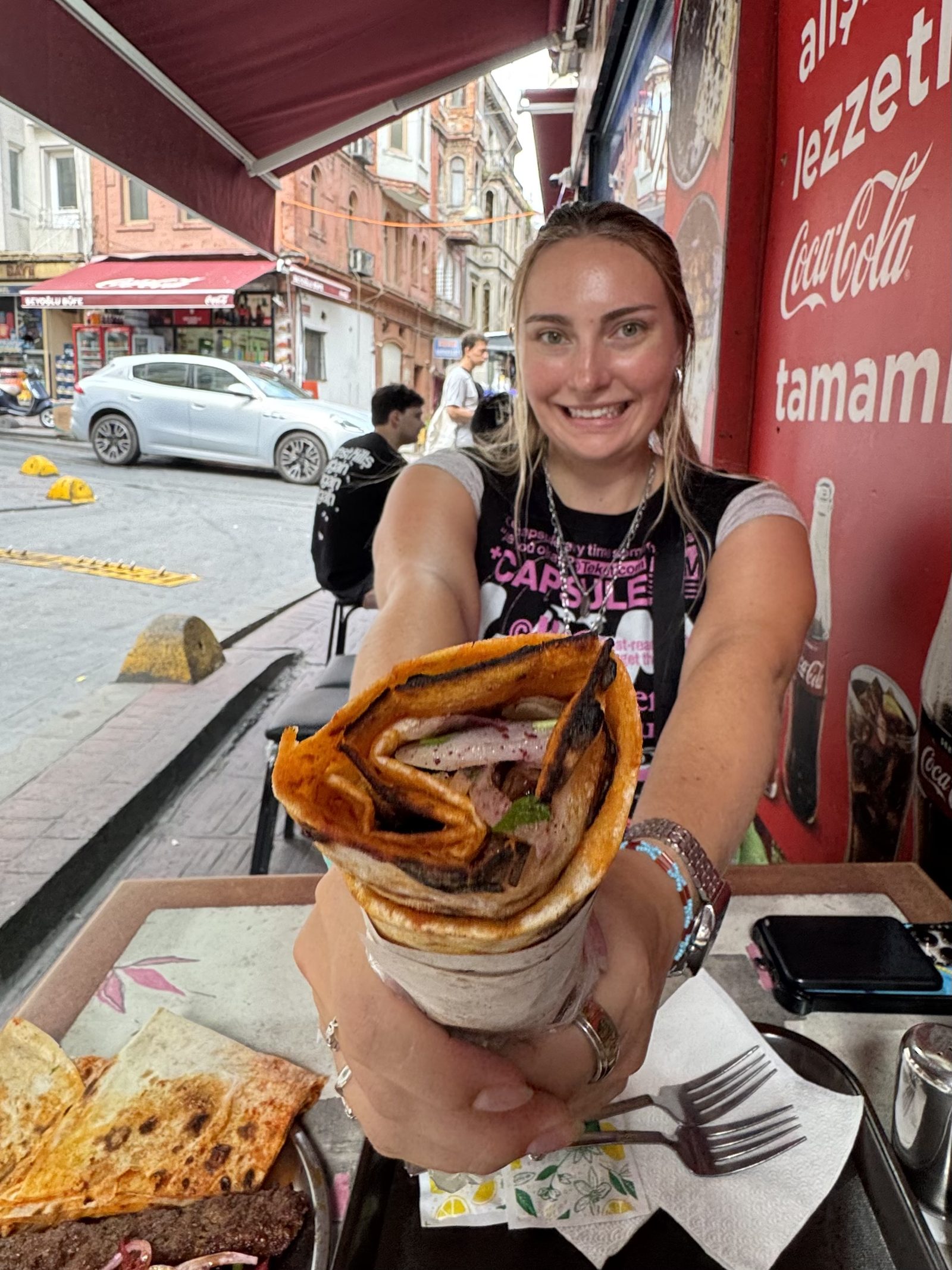 Holding a Turkish street-food wrap on a busy street