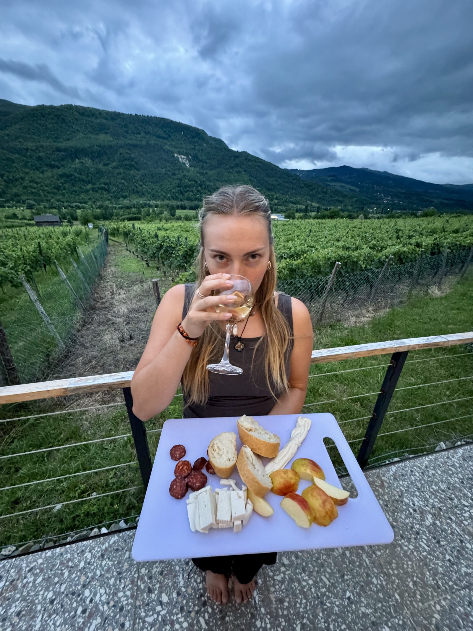 A glass of wine on the deck facing the vineyards