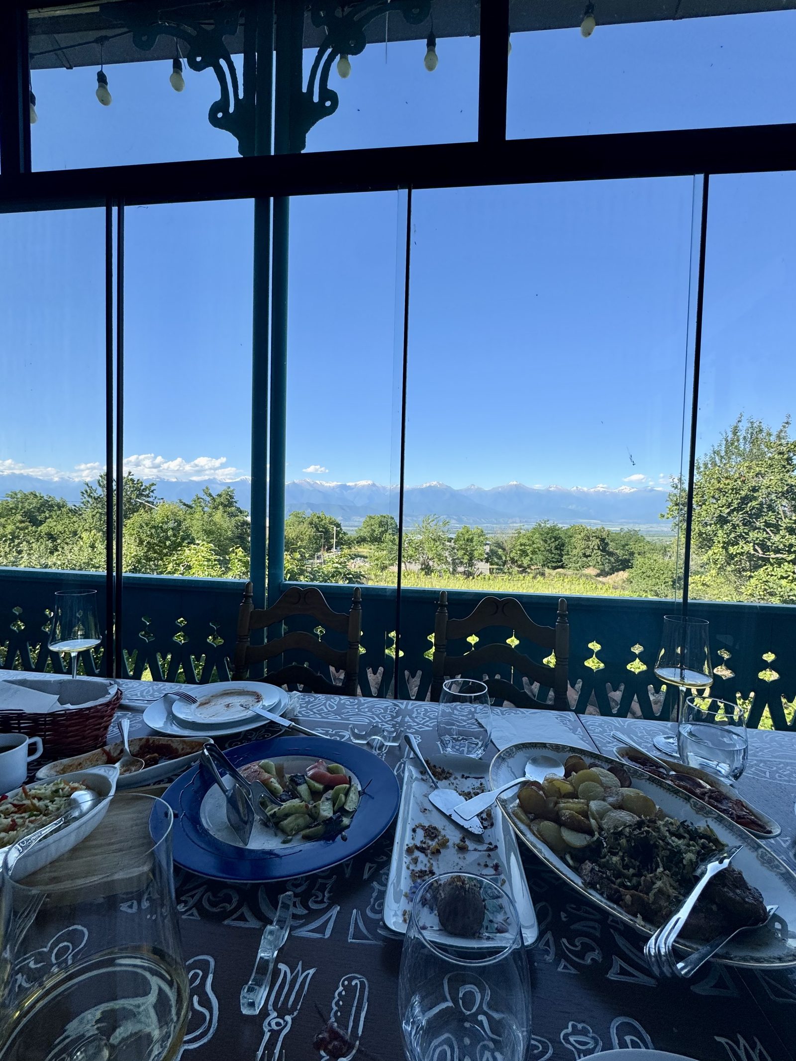 A winery lunch table by windows facing the mountains