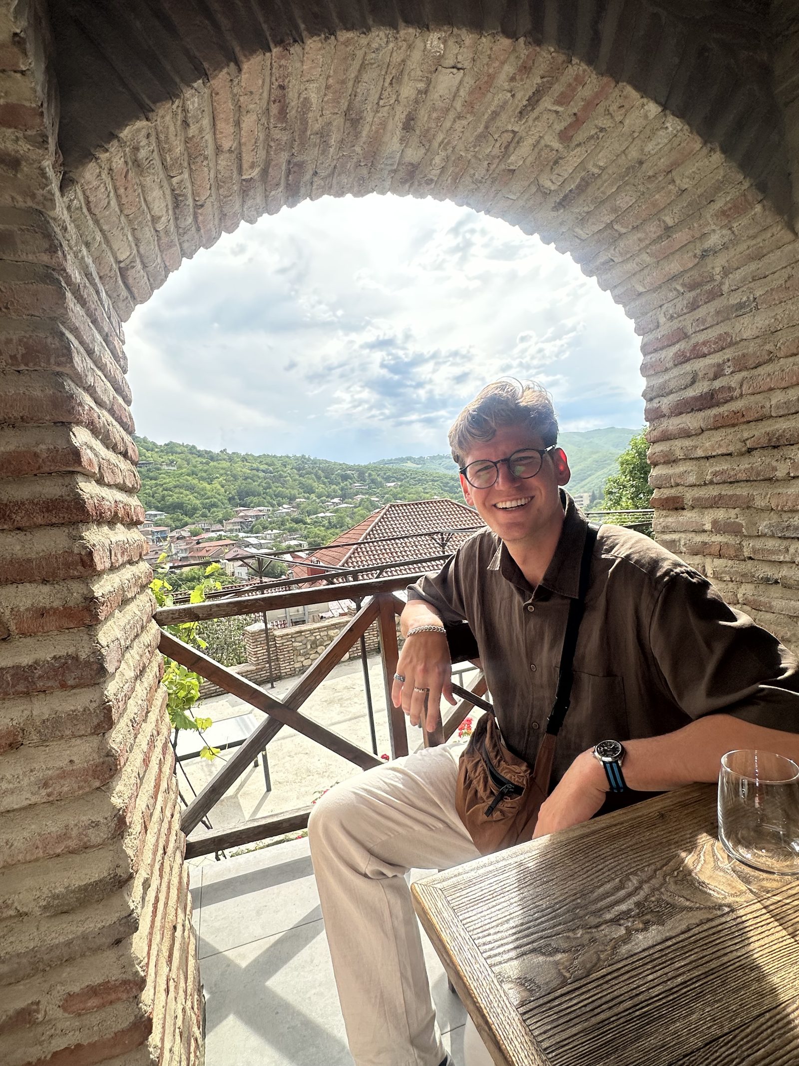 Sitting in a stone archway with wine at the winery