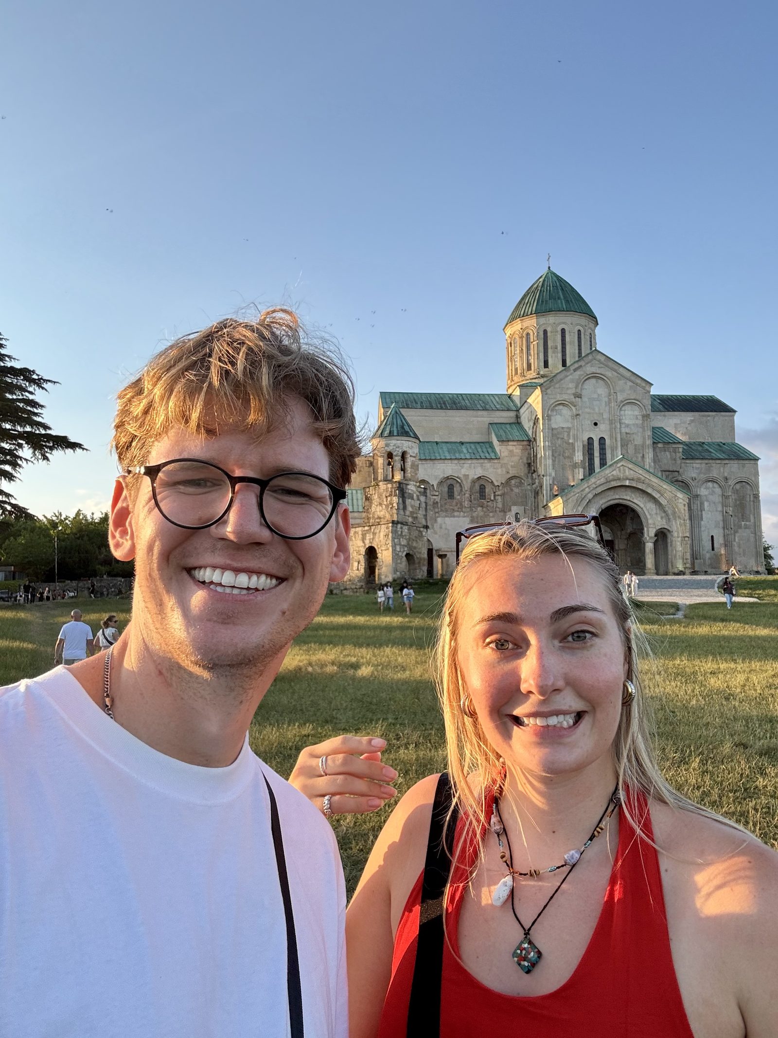 A couple selfie in front of a domed Georgian cathedral