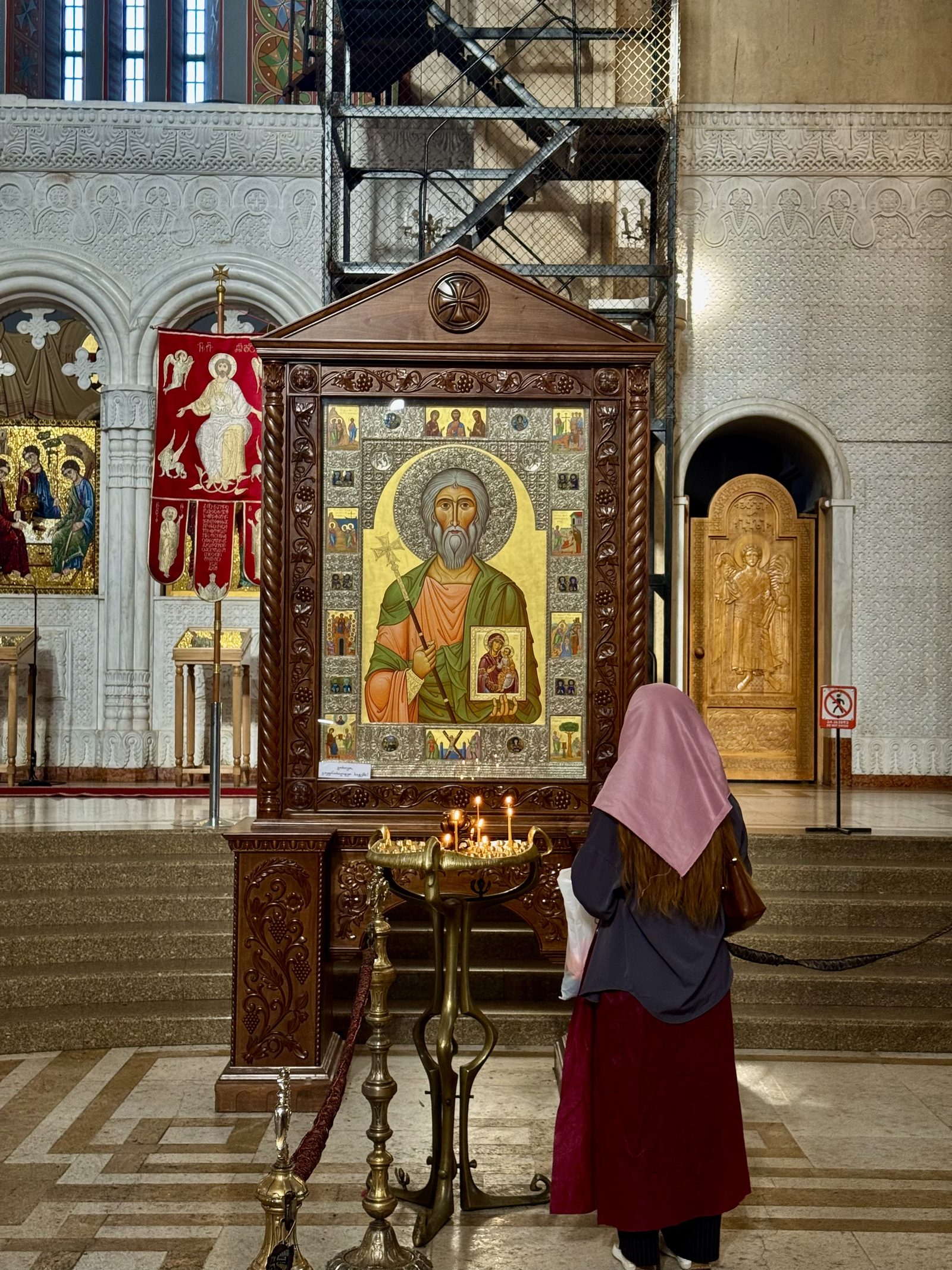 A visitor before a golden icon inside the cathedral