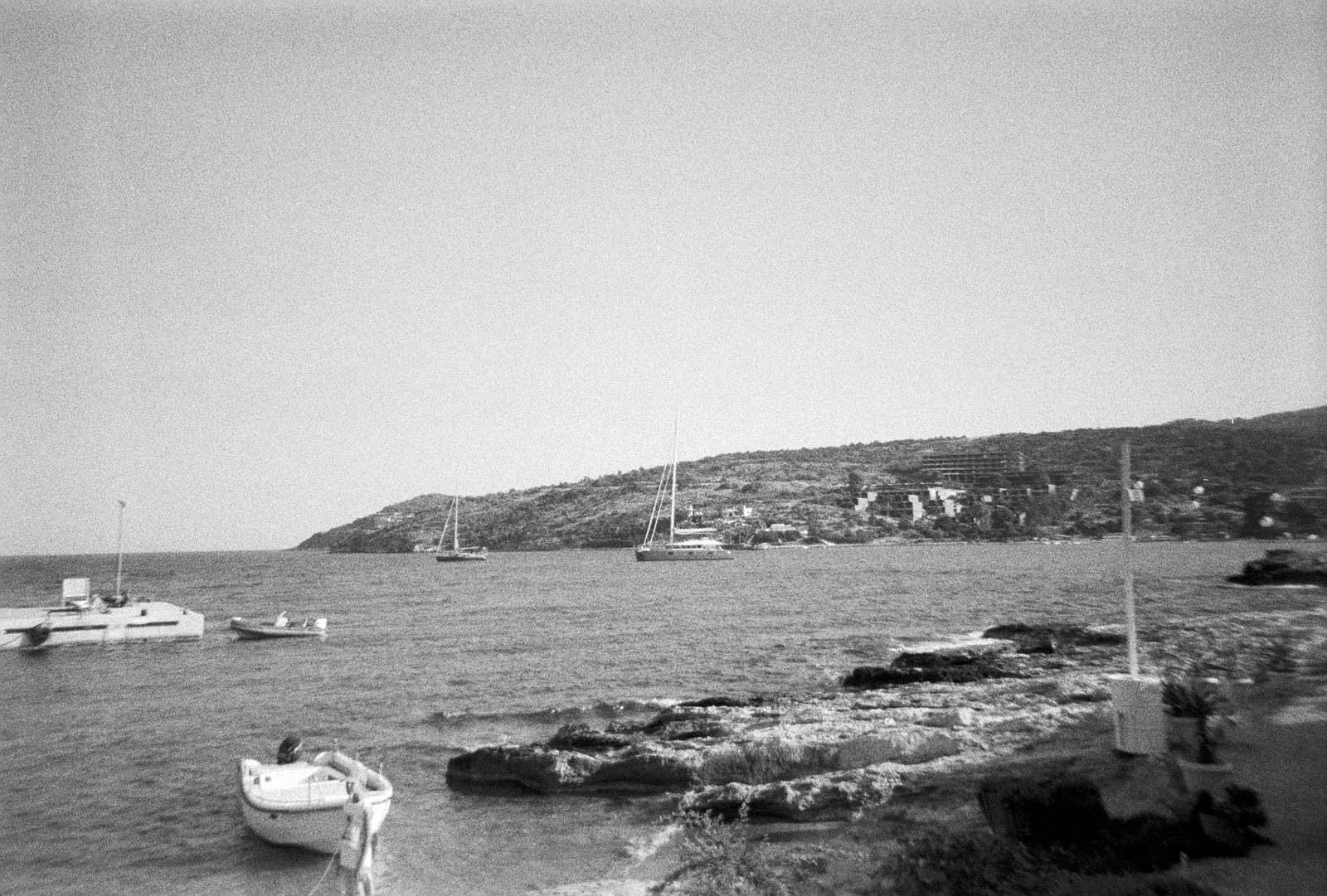 Black and white film photo of the harbor and boats