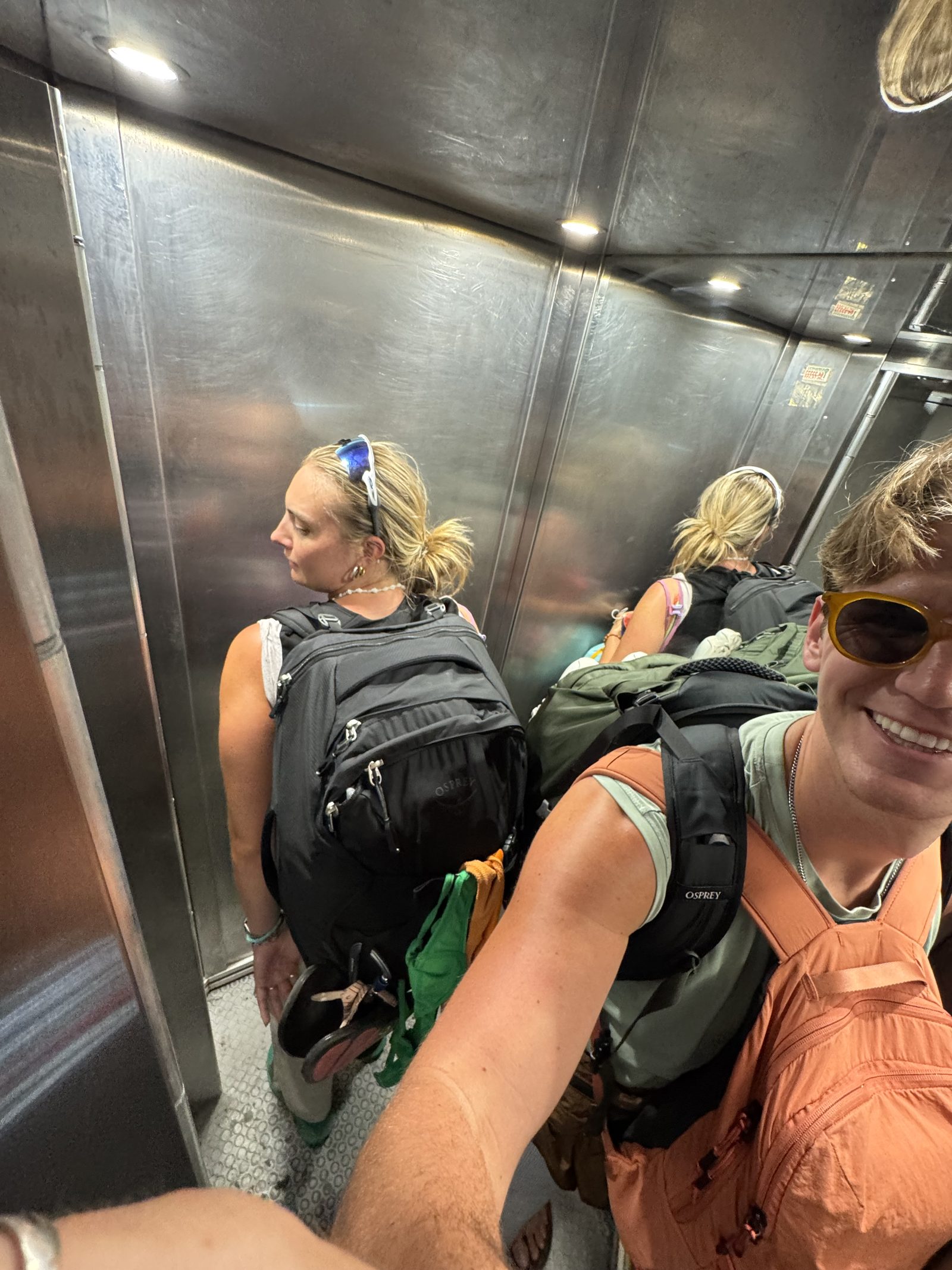 Meg and Ryker in the elevator with their backpacks