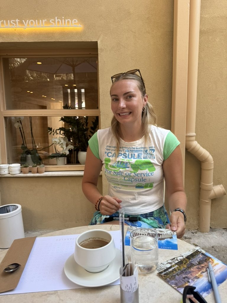 Meg smiling at a coffee table