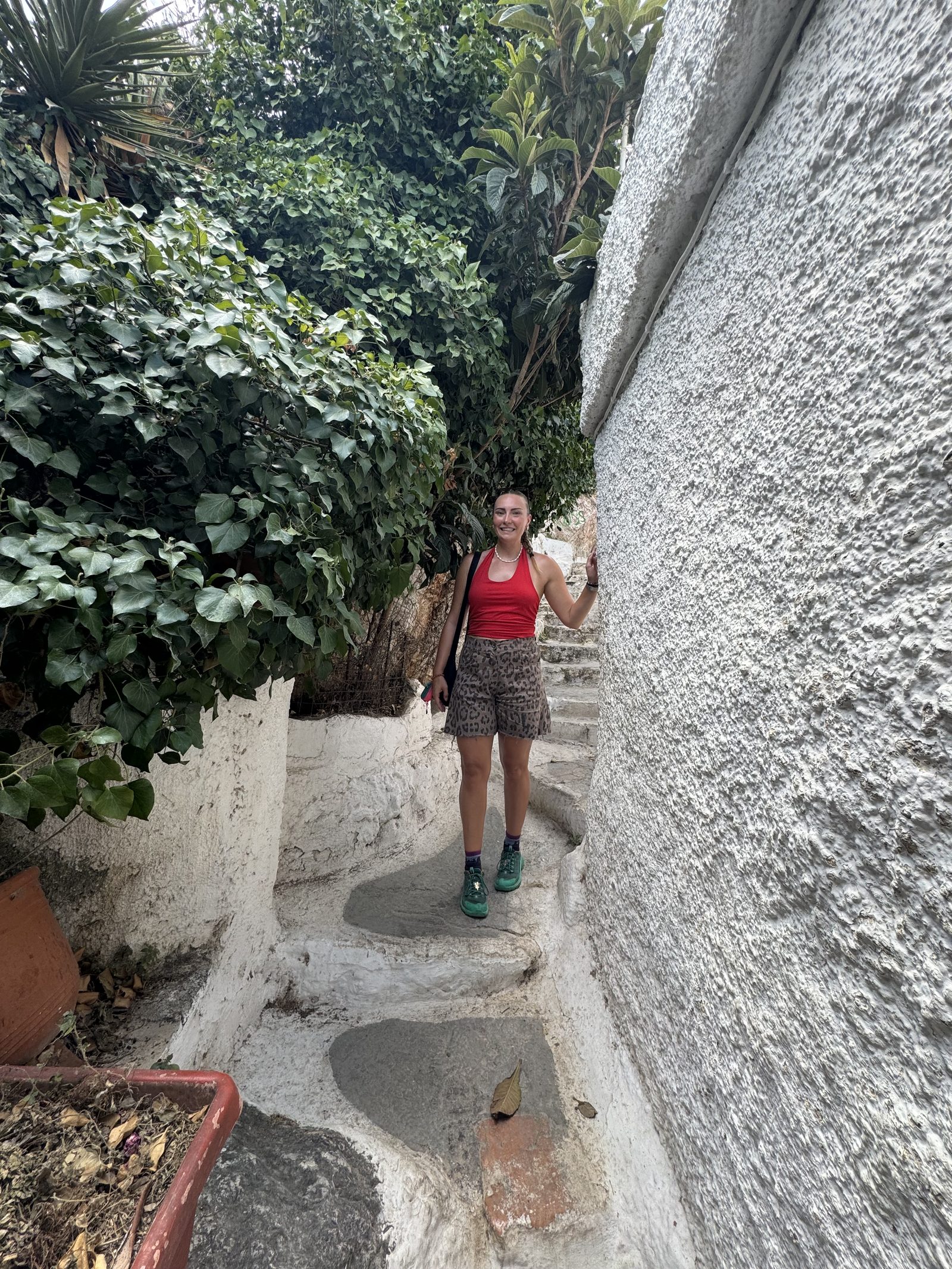 Meg peeking out from a small pathway between white walls