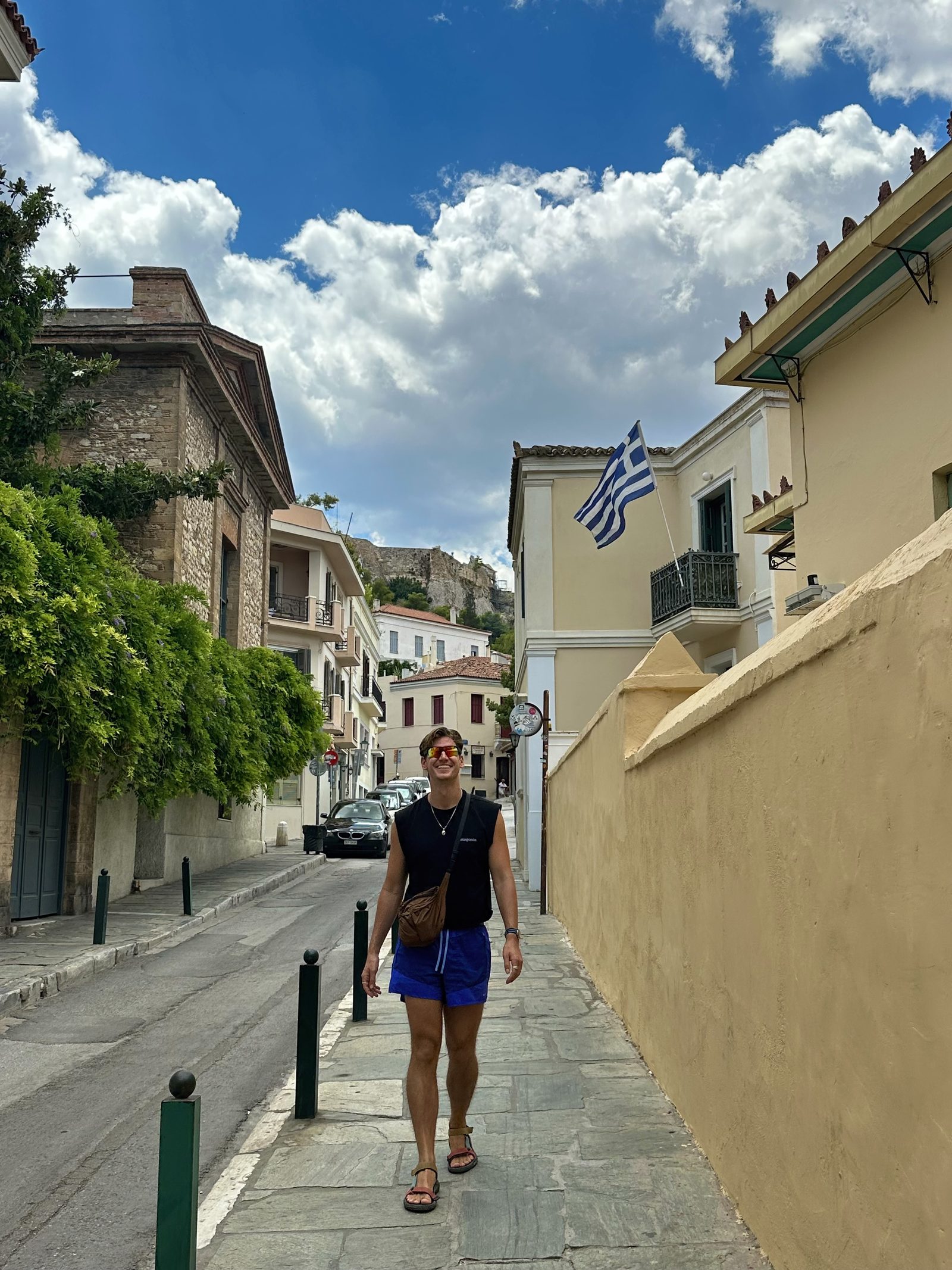 Ryker walking down a street with the Greek flag overhead